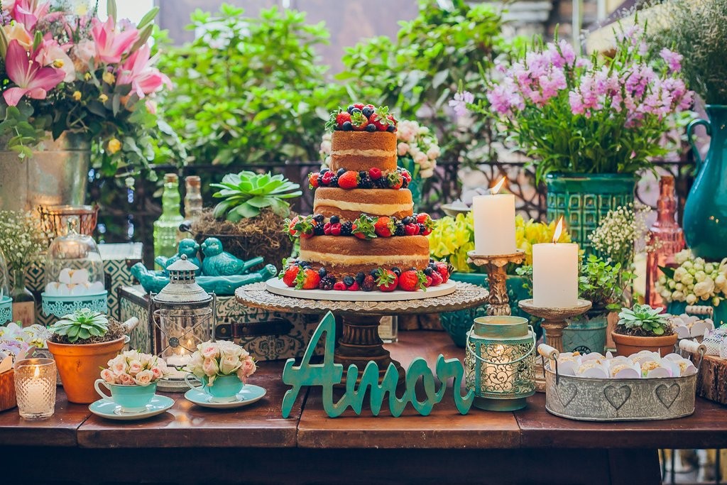 mesa de doces decorada com um bolo naked cake