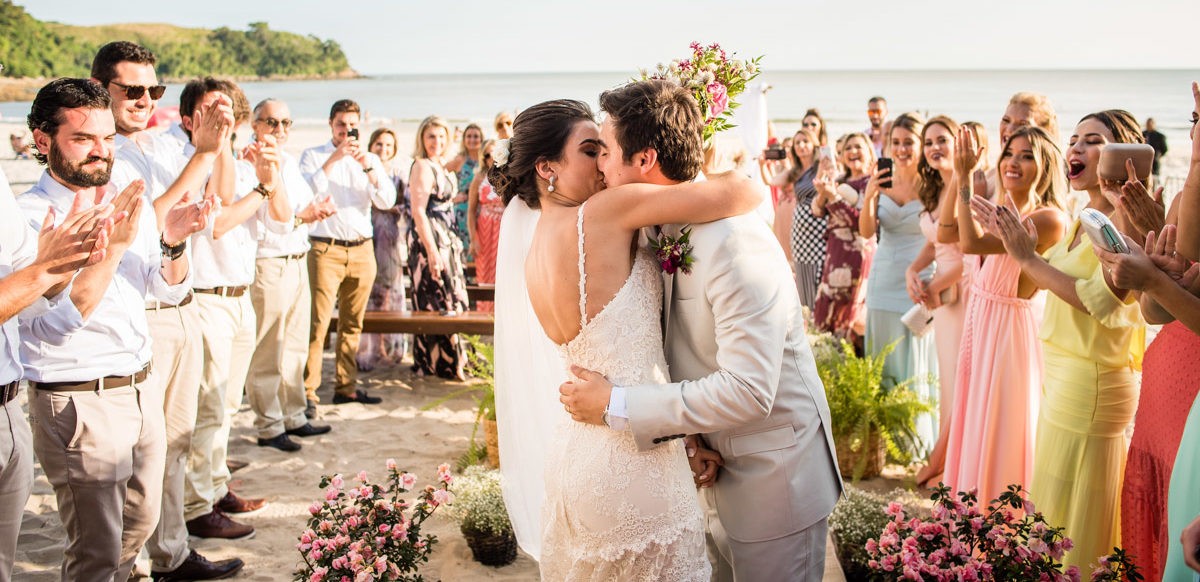 noivo se beijando na cerimônia pé na areia