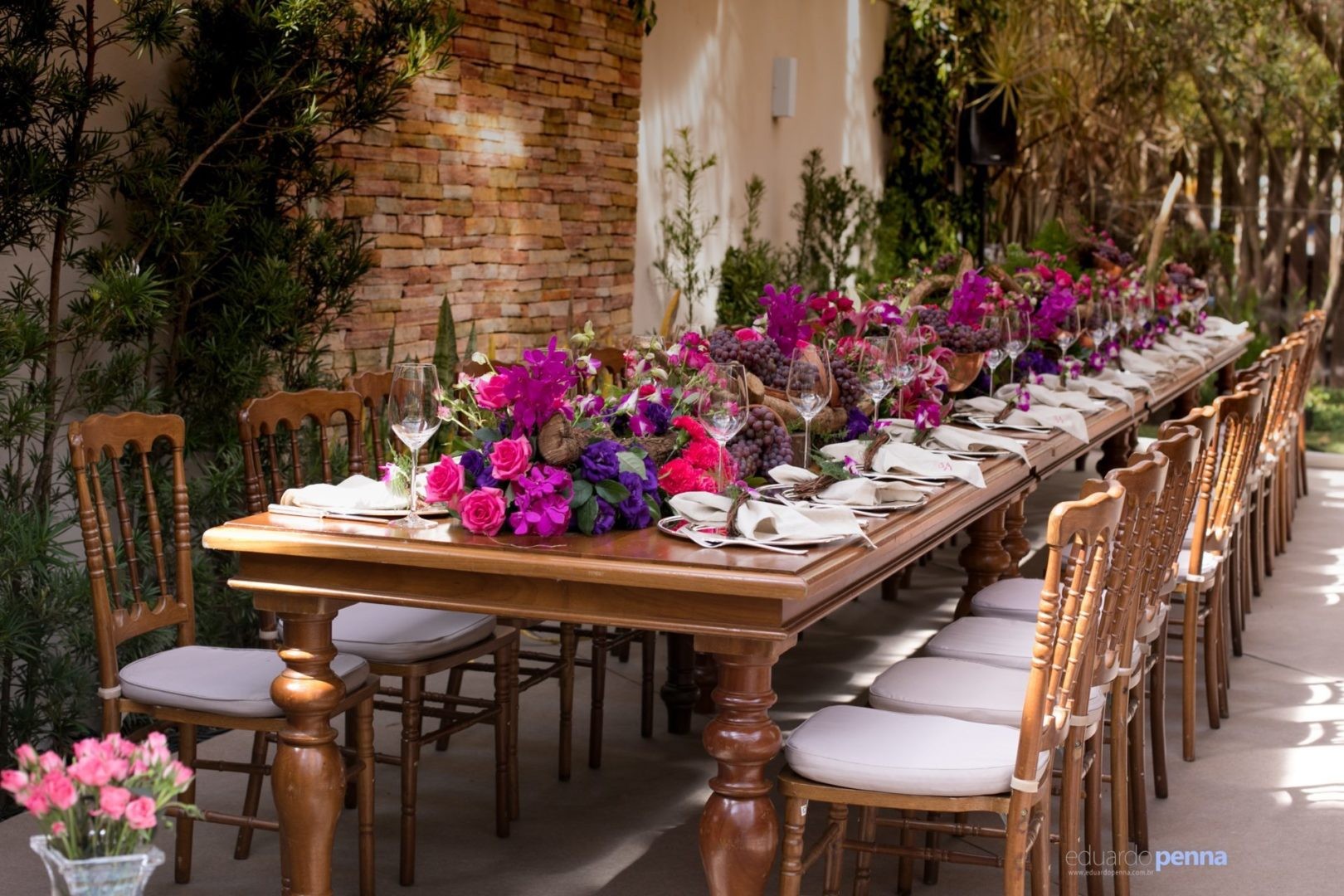 mesa decorada com centros de mesa de flores nas cores rosa e roxo